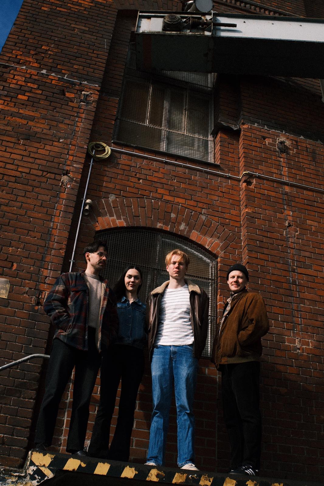YUL band photo in front of a brick building